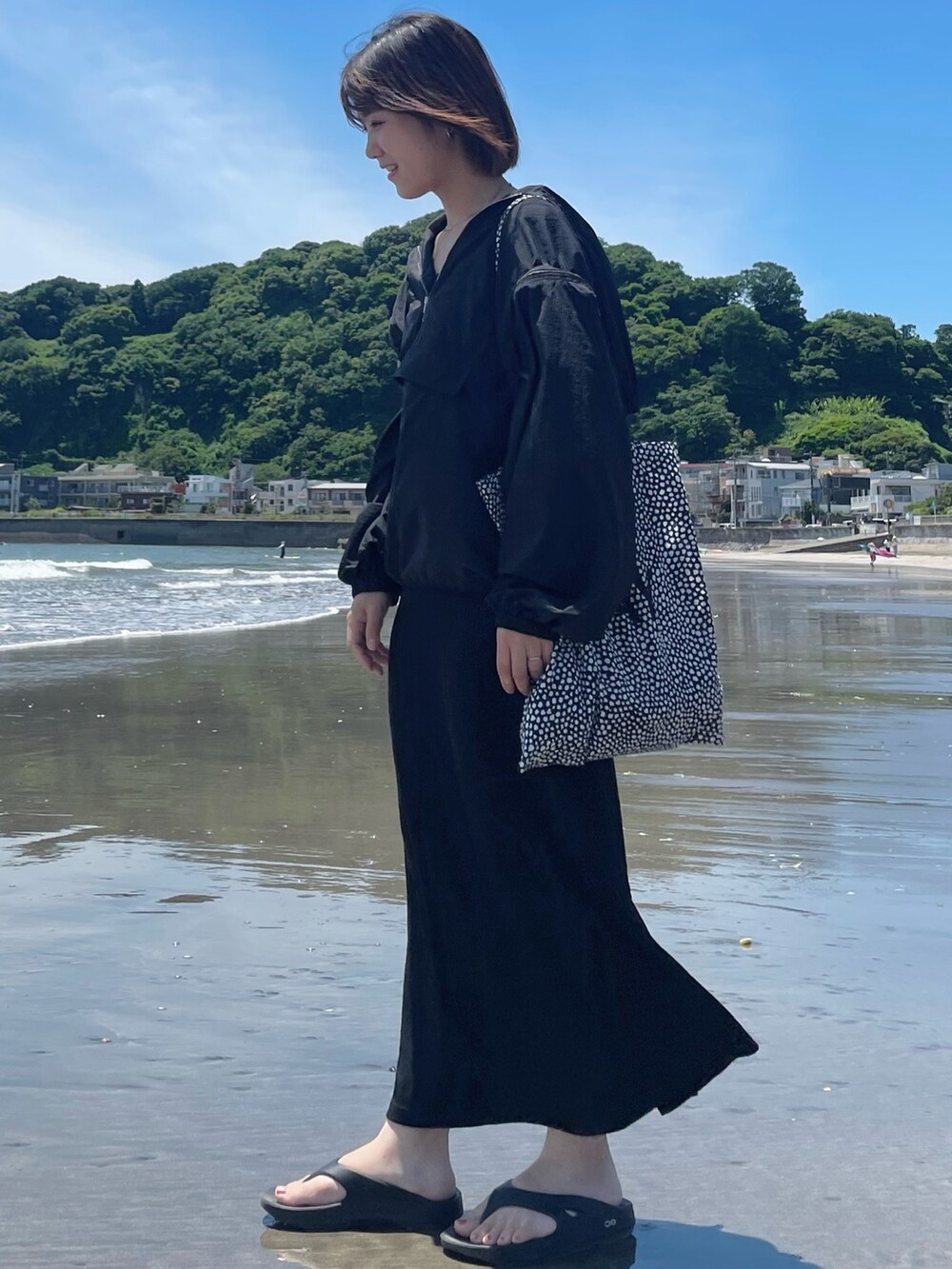 ブラック系のワンピース、ブラック系のパーカー、ブラック系のサンダルを着用したレディースの夏コーディネートの2枚目の写真