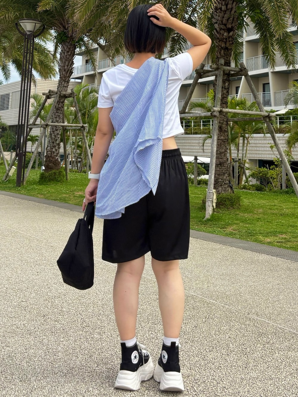 ブルー系のシャツ/ブラウス、ブラック系のスニーカー、ブラック系のトートバッグを着用したレディースの夏コーディネートの2枚目の写真