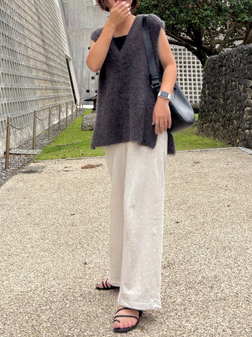 ベージュ系のスウェットパンツ、グレー系のベスト、ブラック系のキャミソールを着用したレディースの秋コーディネートの3枚目の写真