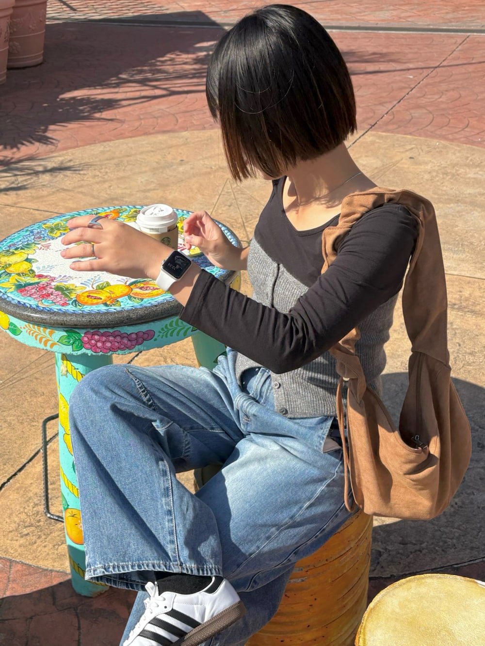 ブルー系のデニムパンツ、ホワイト系のスニーカー、シルバー系のネックレスを着用したレディースの冬コーディネートの3枚目の写真