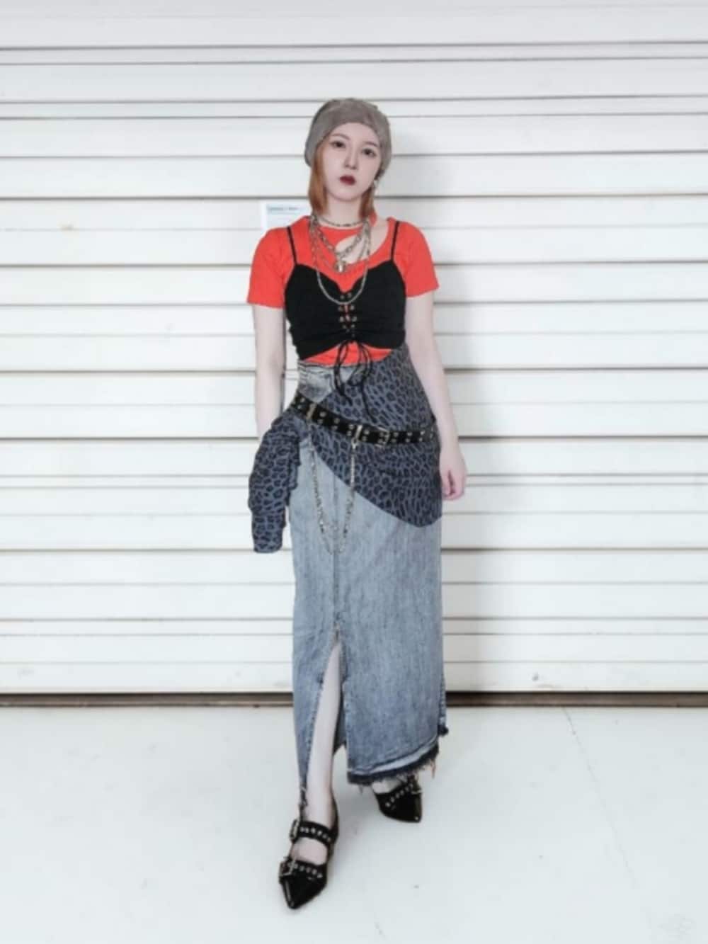 ブラック系のパンプス、グレー系のデニムスカート、オレンジ系のTシャツ/カットソーを着用したレディースの夏コーディネートの2枚目の写真