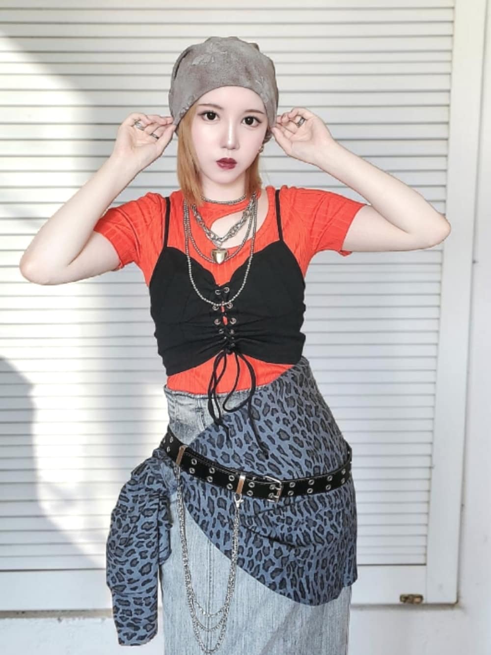 ブラック系のパンプス、グレー系のデニムスカート、オレンジ系のTシャツ/カットソーを着用したレディースの夏コーディネートの3枚目の写真