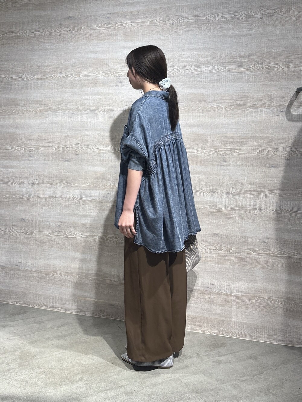 ブルー系のシャツ/ブラウス、グレー系のトートバッグ、ブラウン系のその他パンツを着用したレディースの秋コーディネートの2枚目の写真