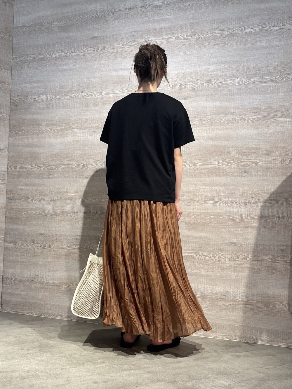 ブラウン系のスカート、ブラック系のTシャツ/カットソーを着用したレディースの夏コーディネートの3枚目の写真