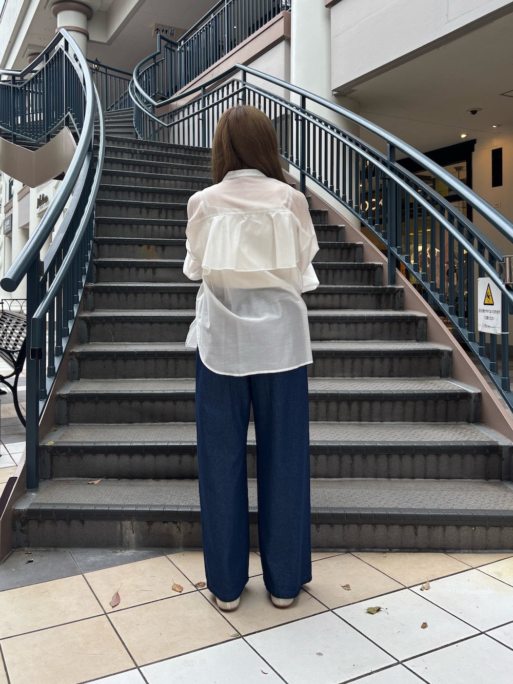 ブルー系のデニムパンツ、ホワイト系のシャツ/ブラウス、シルバー系のトートバッグを着用したレディースの夏コーディネートの3枚目の写真