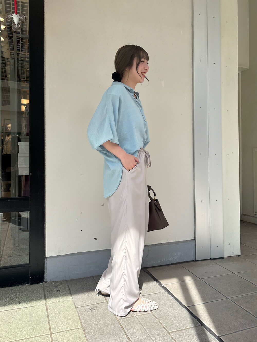 グレー系のその他パンツ、ブルー系のシャツ/ブラウス、シルバー系のサンダルを着用したレディースの夏コーディネートの2枚目の写真