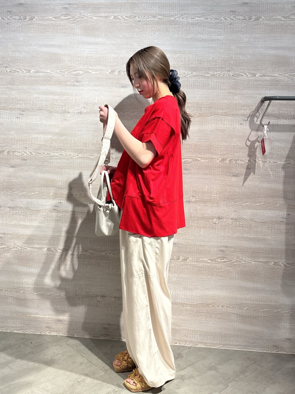 レッド系のTシャツ/カットソー、ベージュ系のその他パンツ、ホワイト系のトートバッグを着用したレディースの春コーディネートの2枚目の写真