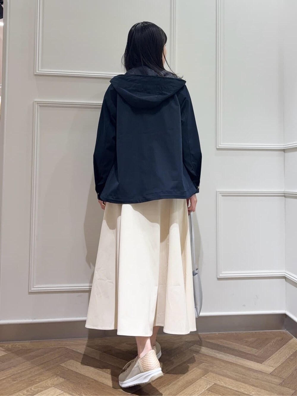 ブルー系のブルゾン、グリーン系のニット/セーター、ホワイト系のスカートを着用したレディースの春コーディネートの3枚目の写真