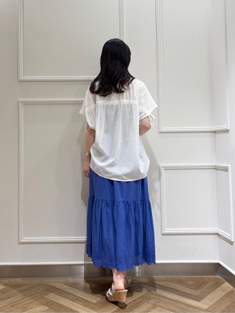 ホワイト系のシャツ/ブラウス、ブルー系のスカート、シルバー系のサンダルを着用したレディースの春コーディネートの3枚目の写真