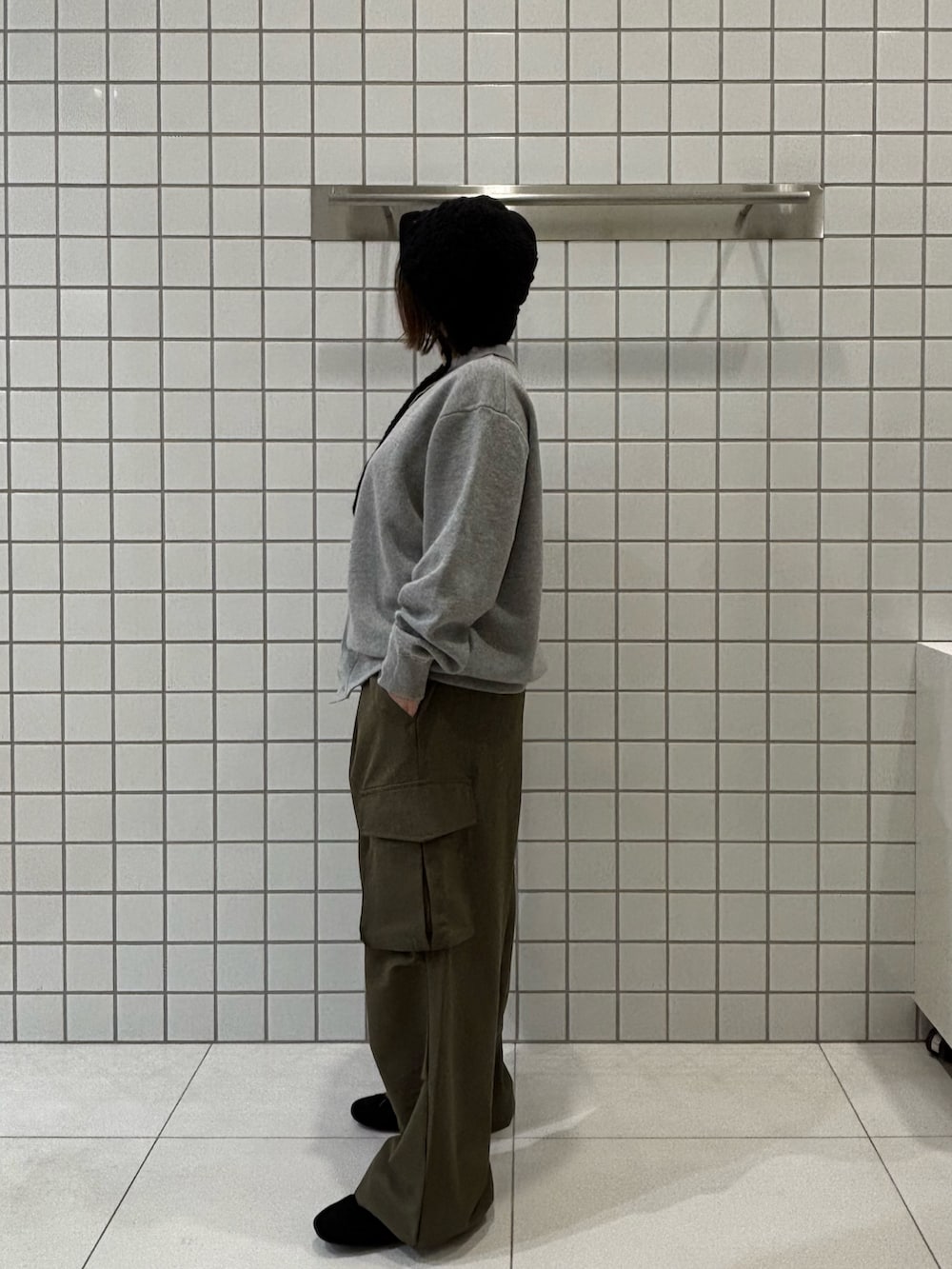 グレー系のカーディガン/ボレロ、グリーン系のカーゴパンツ、ブラック系のスニーカーを着用したレディースの冬コーディネートの2枚目の写真