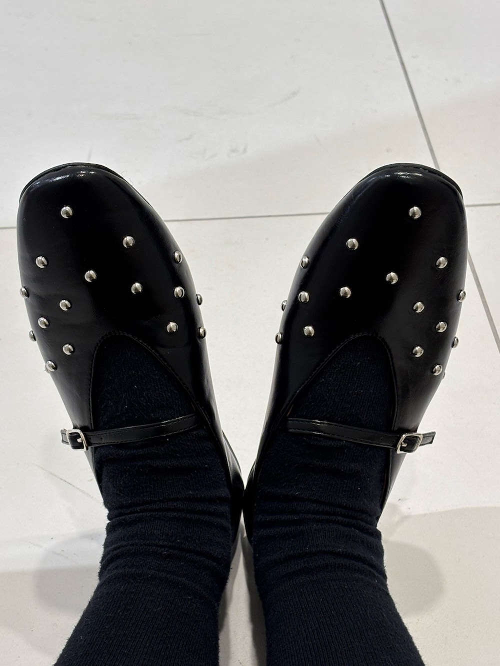 ホワイト系のワンピース、ブラック系のパンプスを着用したレディースの冬コーディネートの3枚目の写真