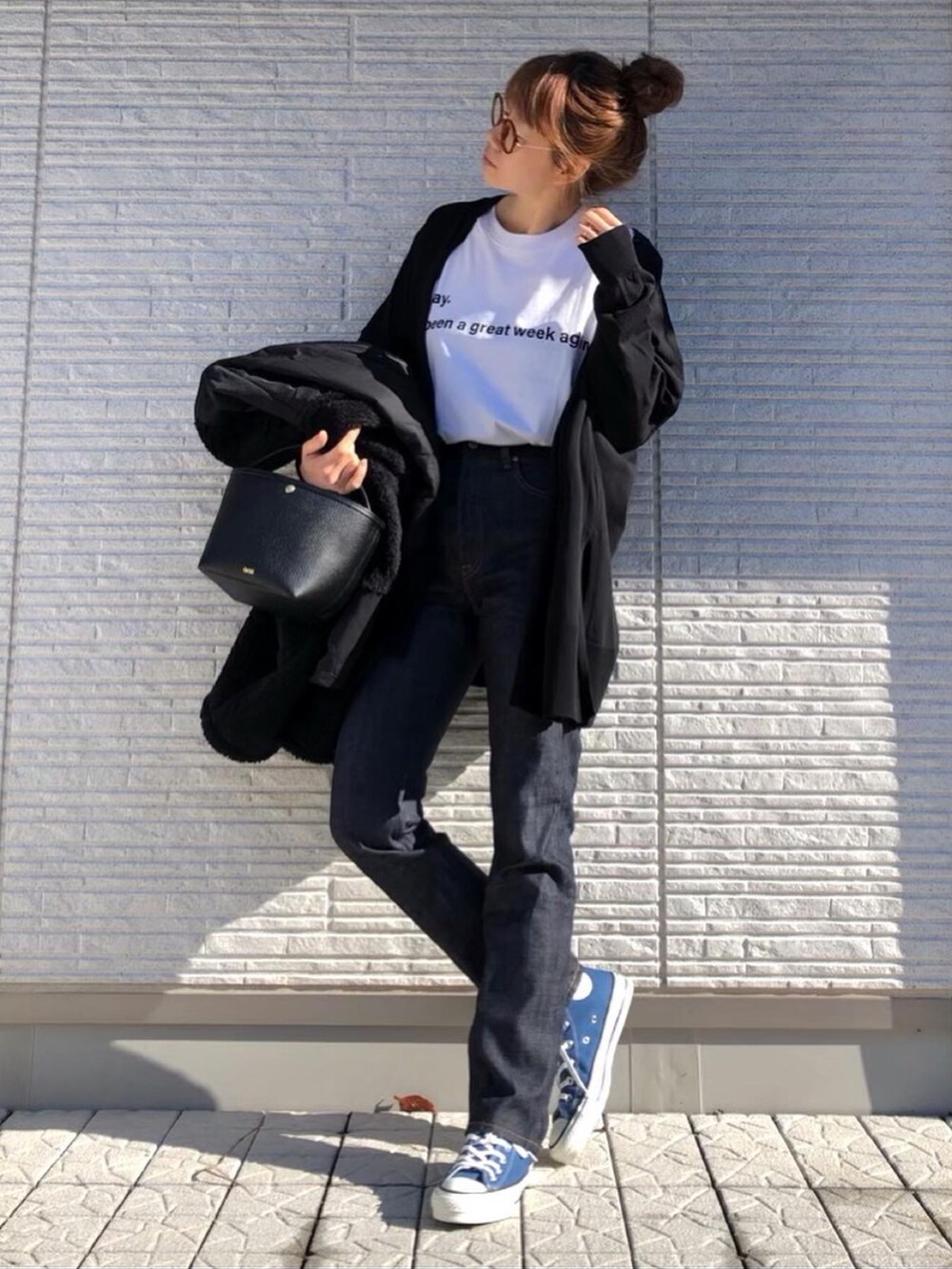 ブラック系のミリタリージャケット、ブルー系のデニムパンツ、ブルー系のスニーカーを着用したレディースの冬コーディネートの2枚目の写真