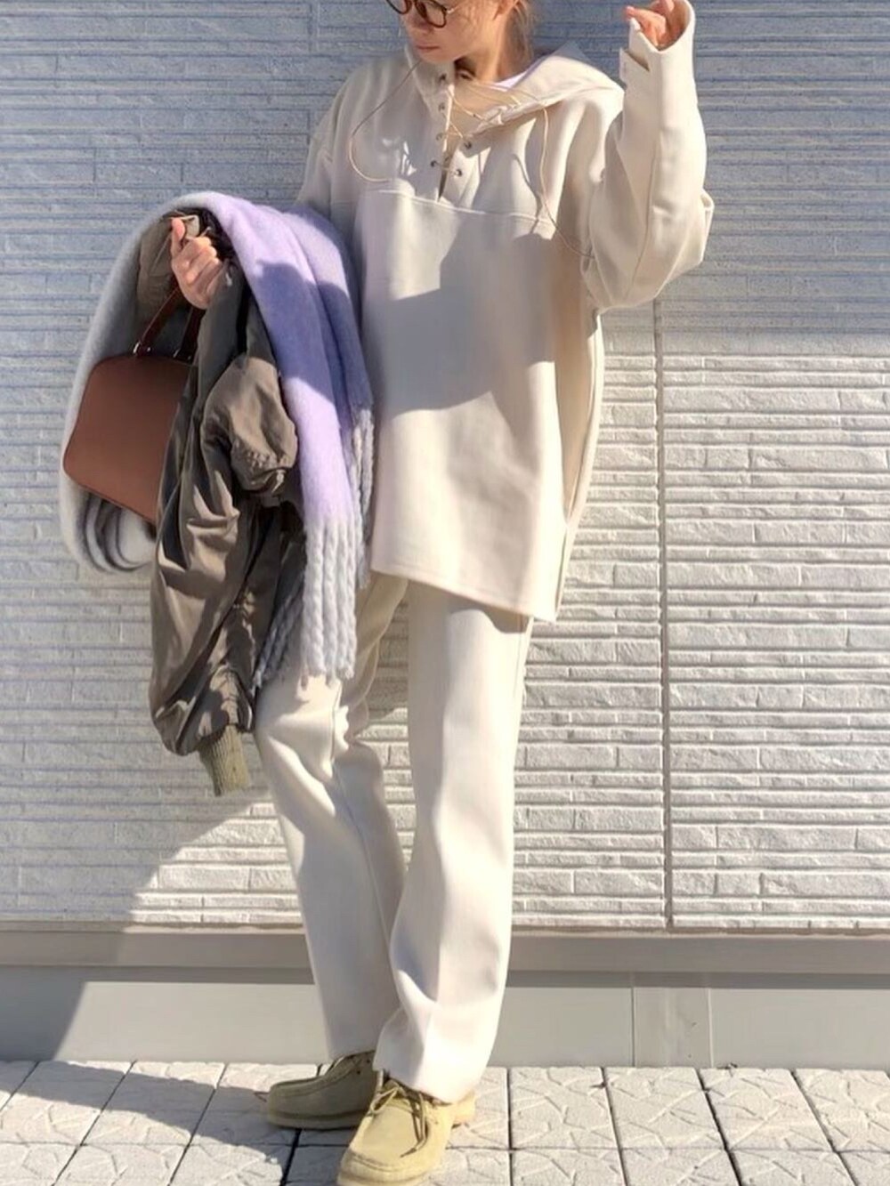 ホワイト系のパーカー、ホワイト系のその他パンツ、ベージュ系のブーツを着用したレディースの冬コーディネートの2枚目の写真