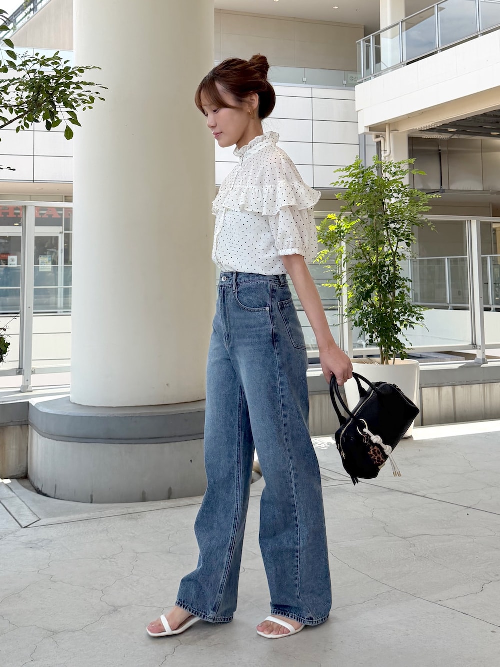 ホワイト系のシャツ/ブラウス、ブルー系のデニムパンツ、ブラック系のボストンバッグを着用したレディースの夏コーディネートの4枚目の写真