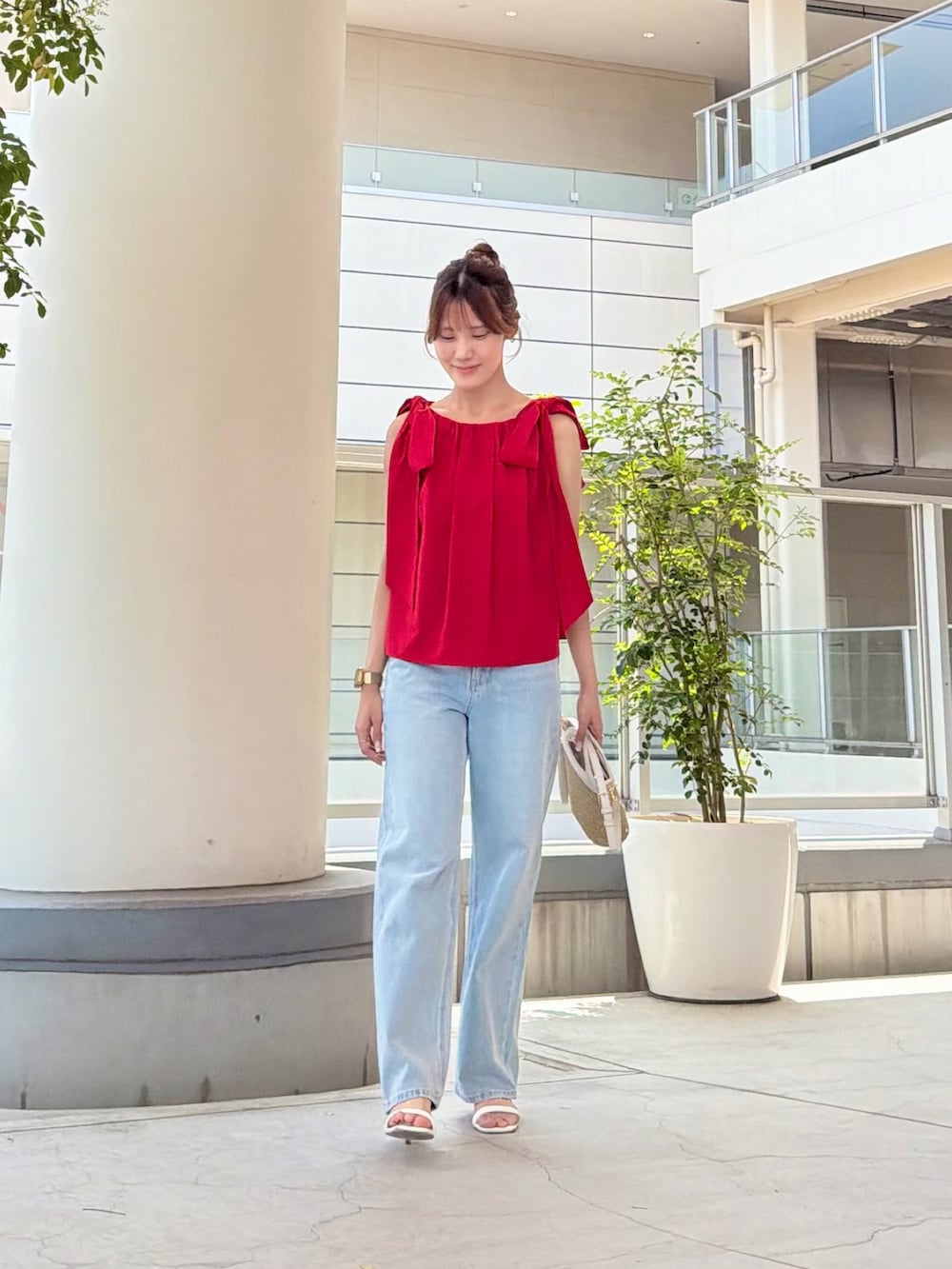 レッド系のシャツ/ブラウス、ブルー系のデニムパンツ、ホワイト系のショルダーバッグを着用したレディースの夏コーディネートの2枚目の写真