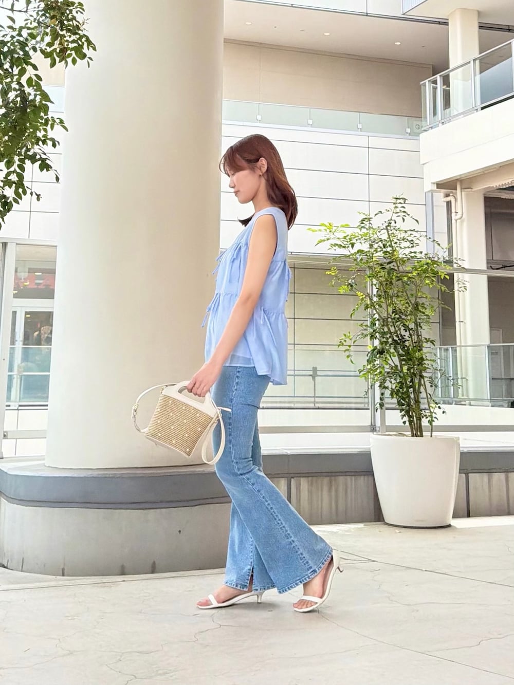 ブルー系のシャツ/ブラウス、ブルー系のデニムパンツ、ホワイト系のショルダーバッグを着用したレディースの夏コーディネートの3枚目の写真