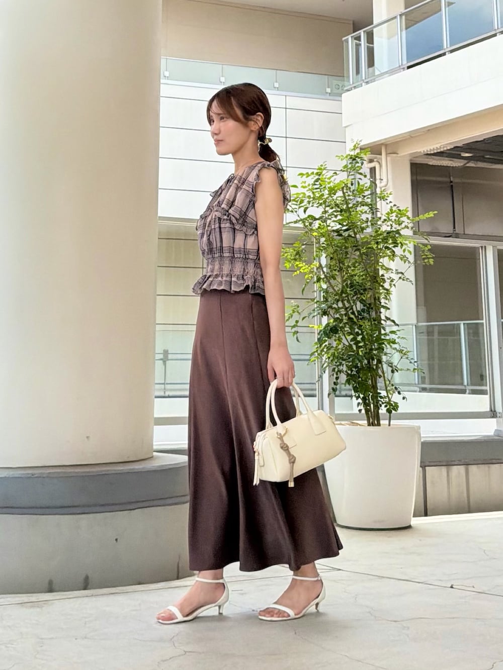 ブラウン系のスカート、ベージュ系のシャツ/ブラウス、ホワイト系のボストンバッグを着用したレディースの夏コーディネートの3枚目の写真