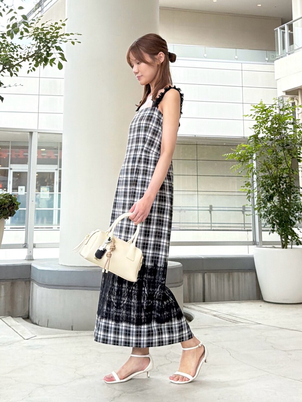 ブラック系のワンピース、ホワイト系のボストンバッグを着用したレディースの夏コーディネートの4枚目の写真