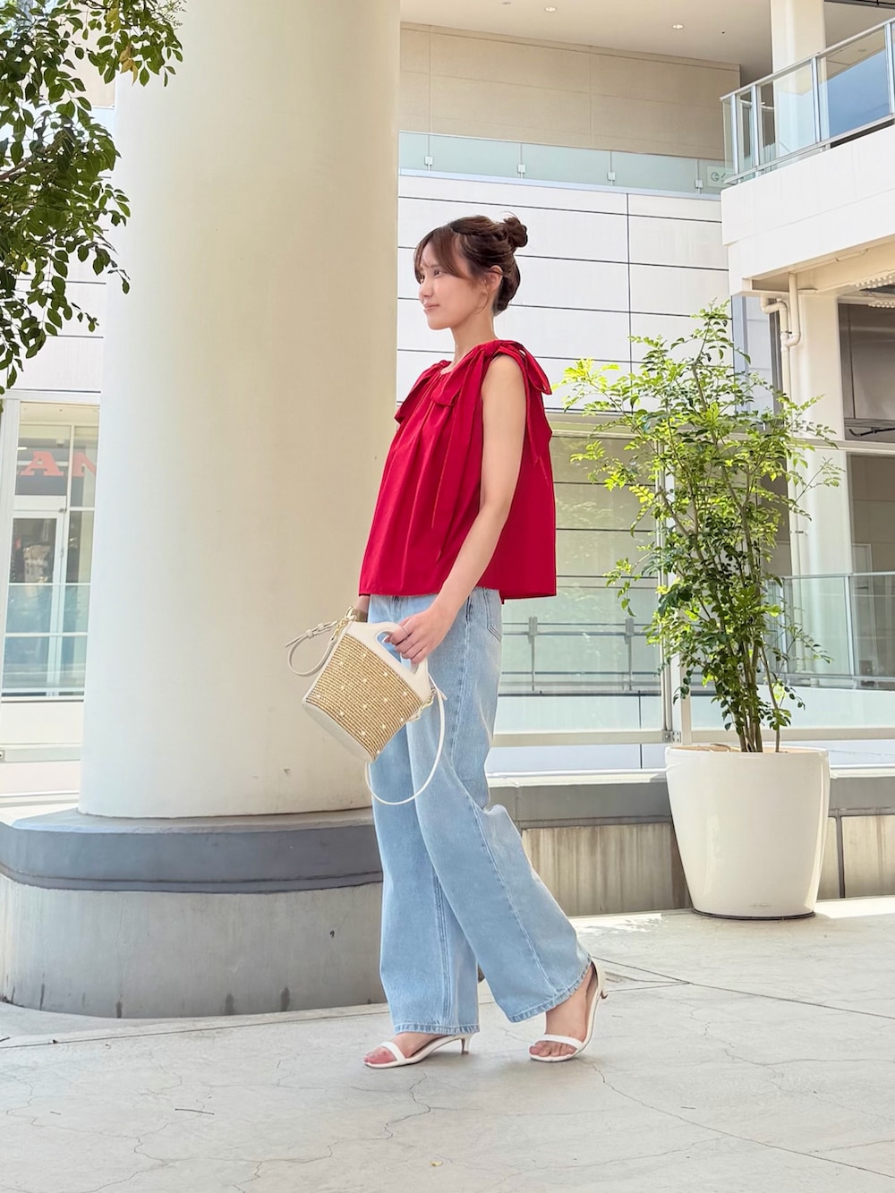 レッド系のシャツ/ブラウス、ブルー系のデニムパンツ、ホワイト系のショルダーバッグを着用したレディースの夏コーディネートの3枚目の写真