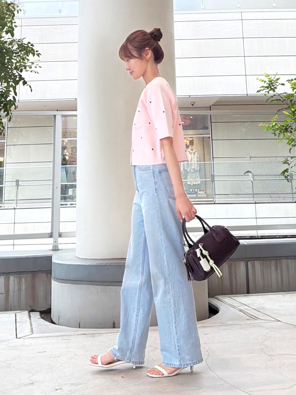 ピンク系のカーディガン/ボレロ、ブルー系のデニムパンツ、ホワイト系のボストンバッグを着用したレディースの夏コーディネートの4枚目の写真