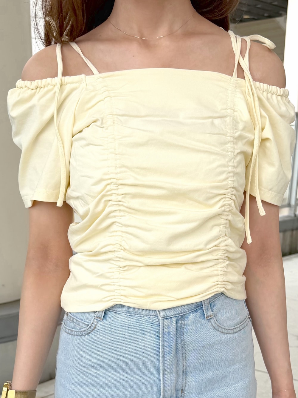イエロー系のTシャツ/カットソー、ブルー系のデニムパンツ、ブラウン系のボストンバッグを着用したレディースの夏コーディネートの6枚目の写真