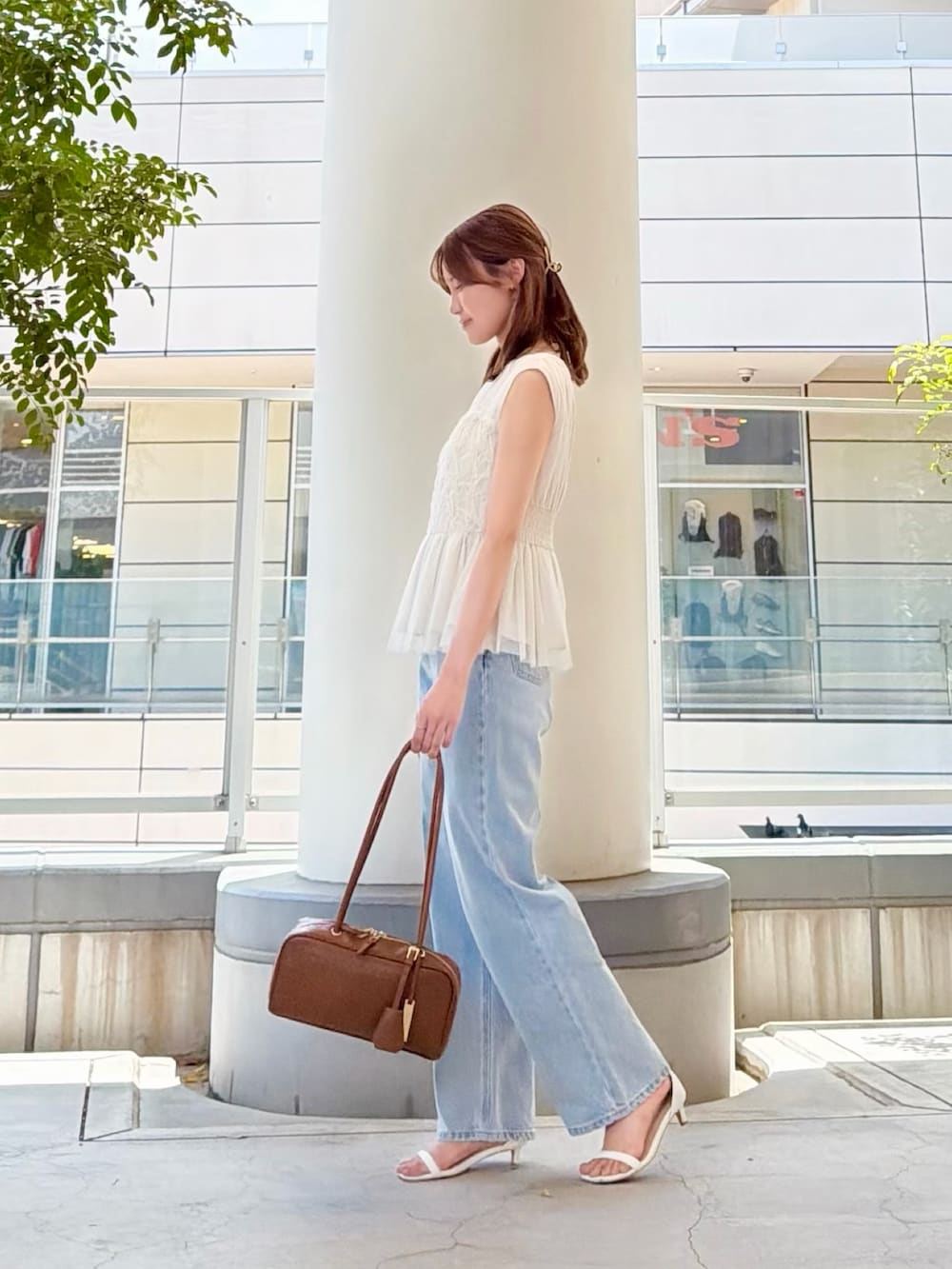 ホワイト系のシャツ/ブラウス、ブルー系のデニムパンツ、ブラウン系のボストンバッグを着用したレディースの夏コーディネートの3枚目の写真