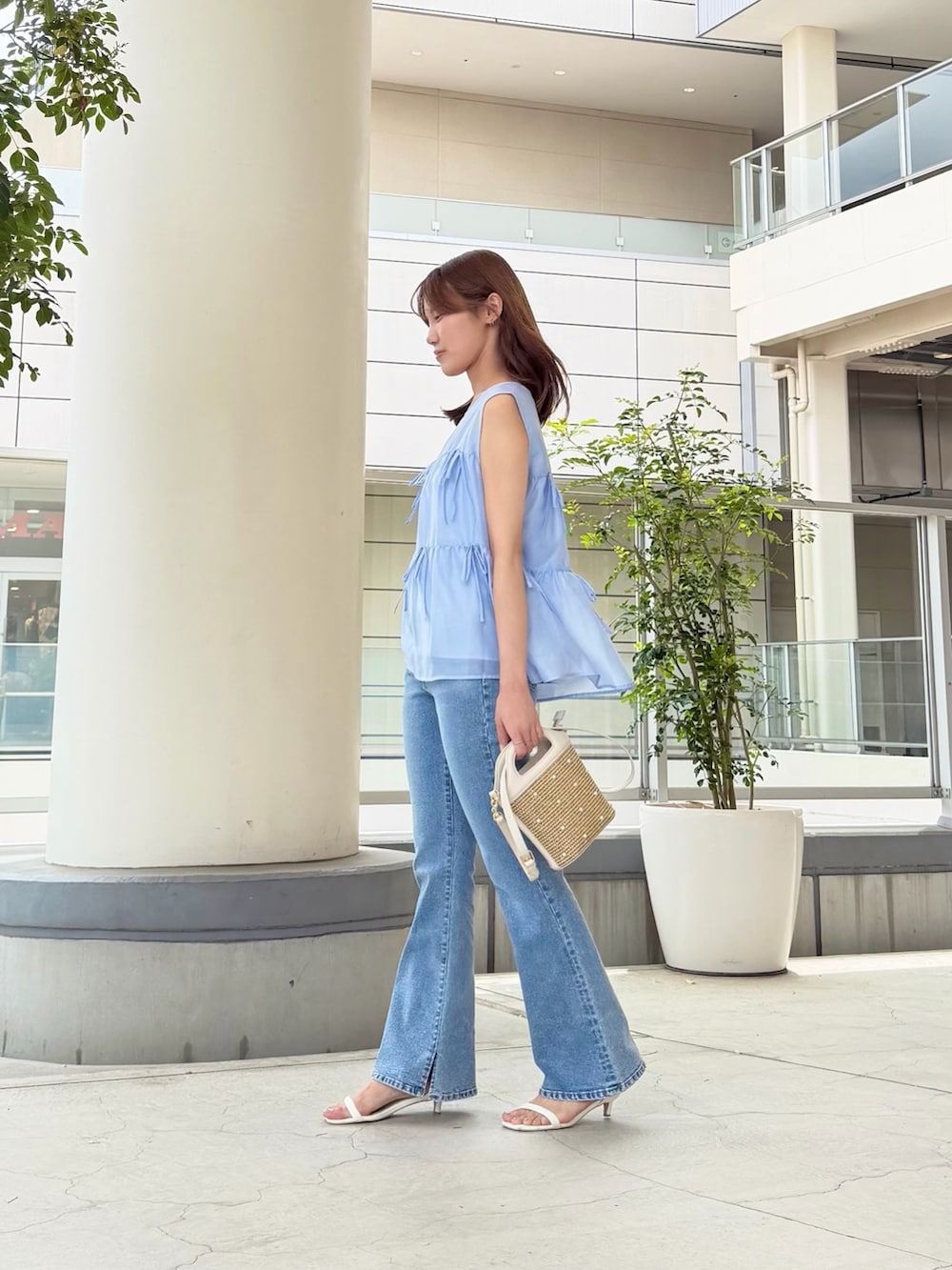 ブルー系のシャツ/ブラウス、ブルー系のデニムパンツ、ホワイト系のショルダーバッグを着用したレディースの夏コーディネートの2枚目の写真