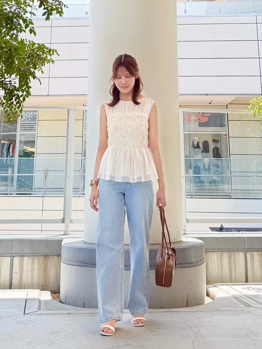 ホワイト系のシャツ/ブラウス、ブルー系のデニムパンツ、ブラウン系のボストンバッグを着用したレディースの夏コーディネートの2枚目の写真