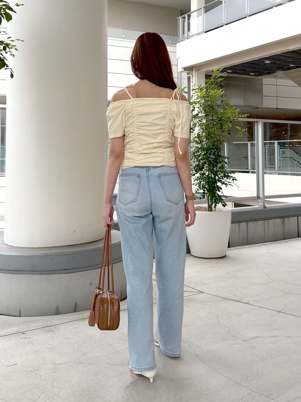 イエロー系のTシャツ/カットソー、ブルー系のデニムパンツ、ブラウン系のボストンバッグを着用したレディースの夏コーディネートの5枚目の写真