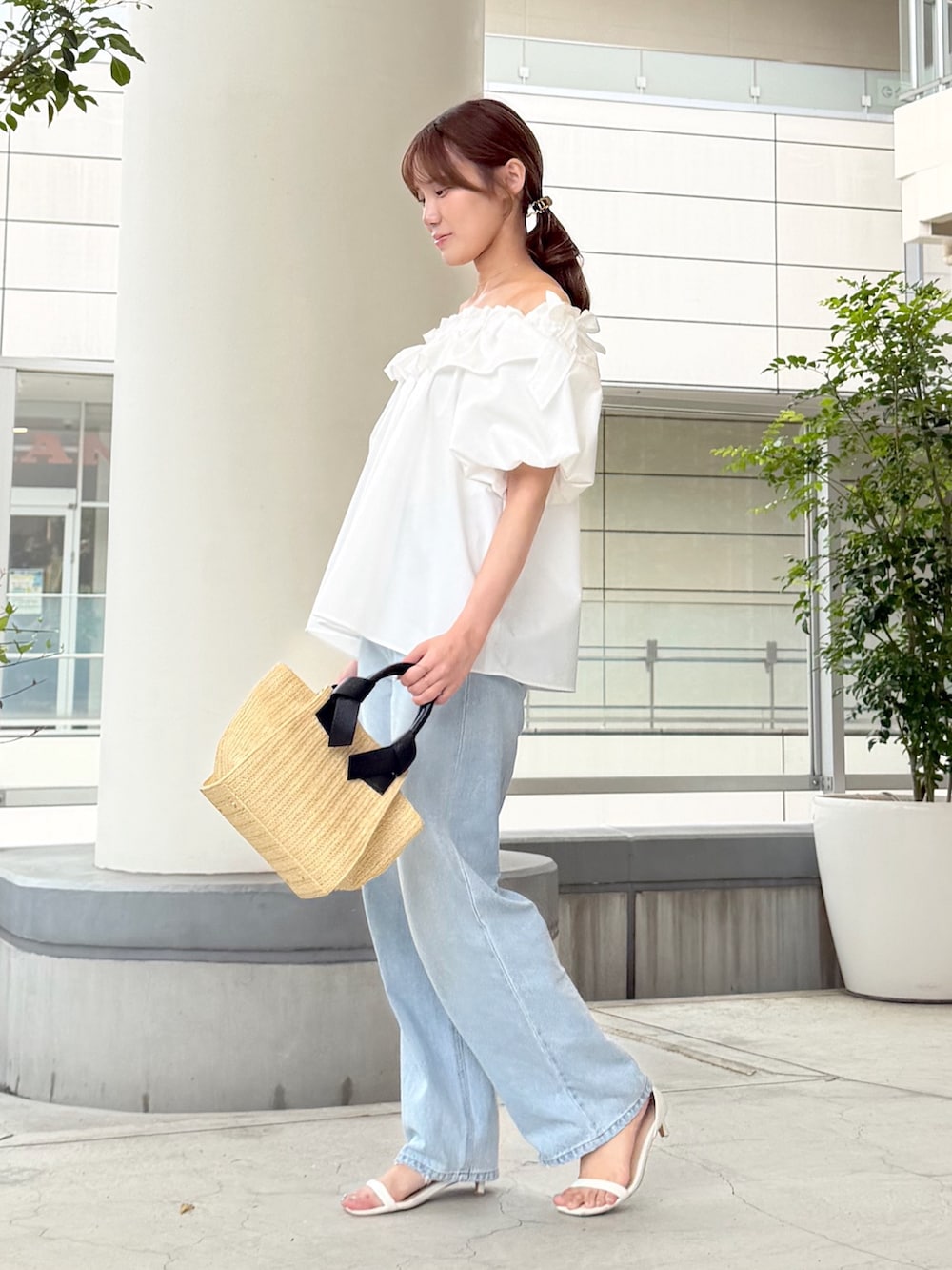 ホワイト系のシャツ/ブラウス、ブルー系のデニムパンツ、ベージュ系のトートバッグを着用したレディースの夏コーディネートの3枚目の写真