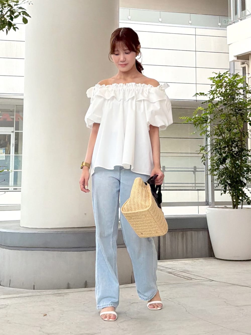 ホワイト系のシャツ/ブラウス、ブルー系のデニムパンツ、ベージュ系のトートバッグを着用したレディースの夏コーディネートの2枚目の写真