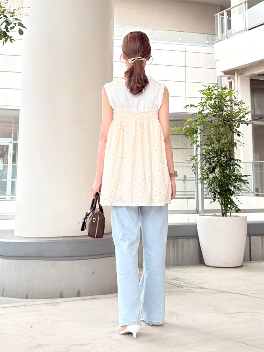 ホワイト系のキャミソール、ホワイト系のTシャツ/カットソー、ブルー系のデニムパンツを着用したレディースの夏コーディネートの5枚目の写真