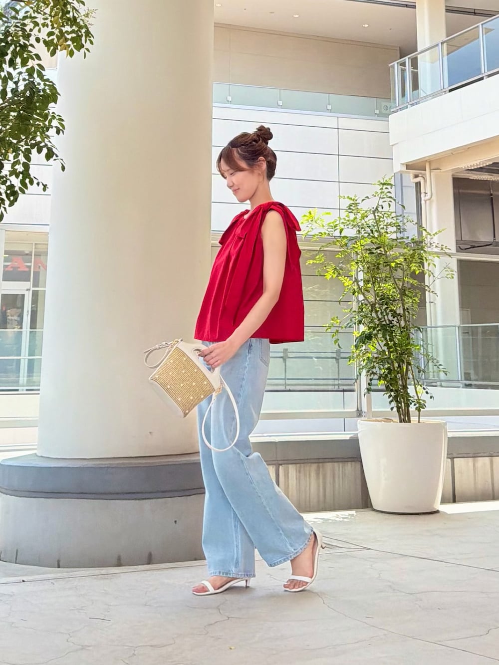 レッド系のシャツ/ブラウス、ブルー系のデニムパンツ、ホワイト系のショルダーバッグを着用したレディースの夏コーディネートの4枚目の写真