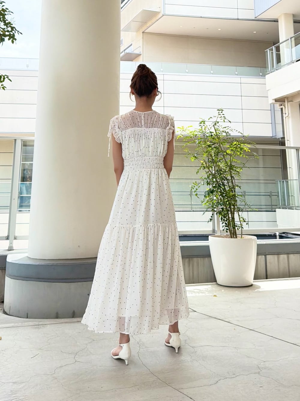 ホワイト系のワンピース、ベージュ系のトートバッグを着用したレディースの夏コーディネートの4枚目の写真