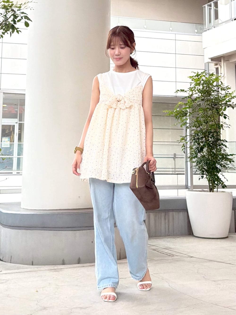 ホワイト系のキャミソール、ホワイト系のTシャツ/カットソー、ブルー系のデニムパンツを着用したレディースの夏コーディネートの2枚目の写真