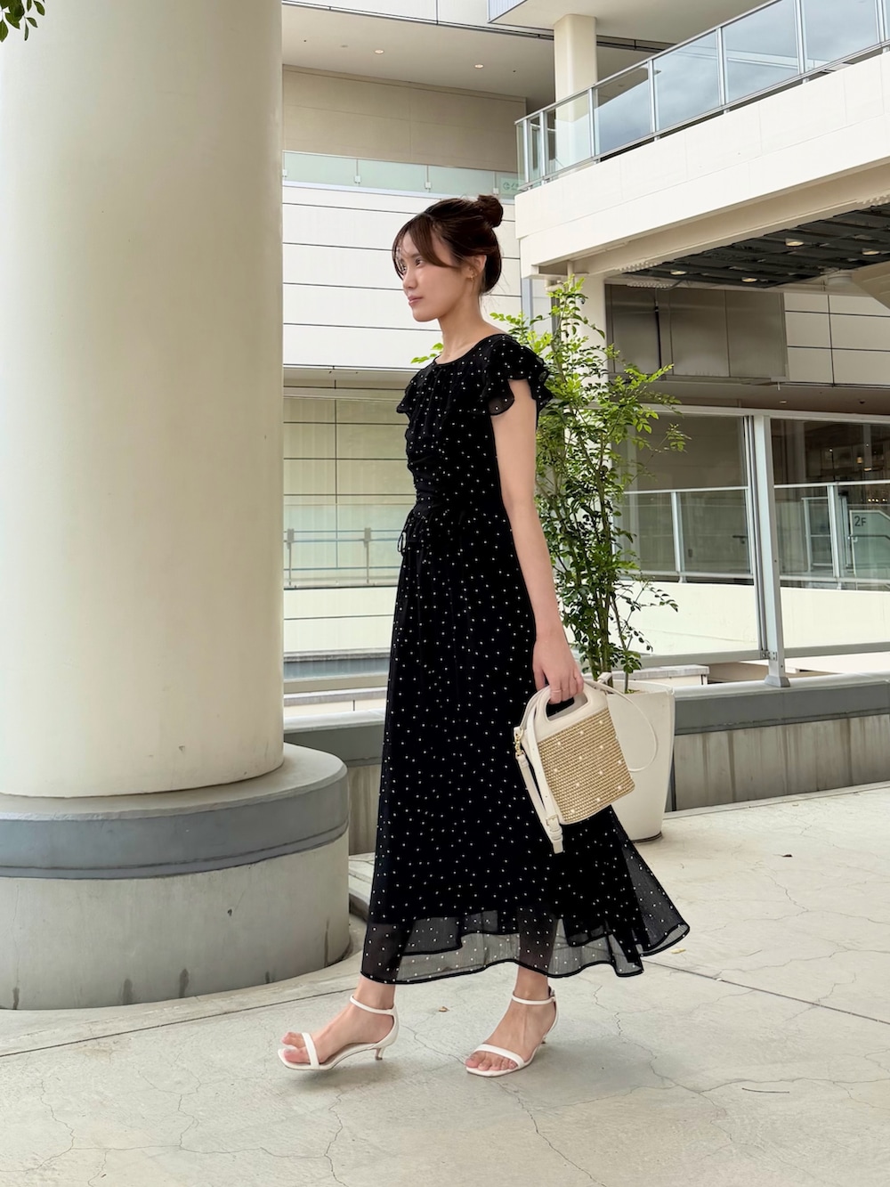 ブラック系のワンピース、ホワイト系のショルダーバッグを着用したレディースの夏コーディネートの2枚目の写真