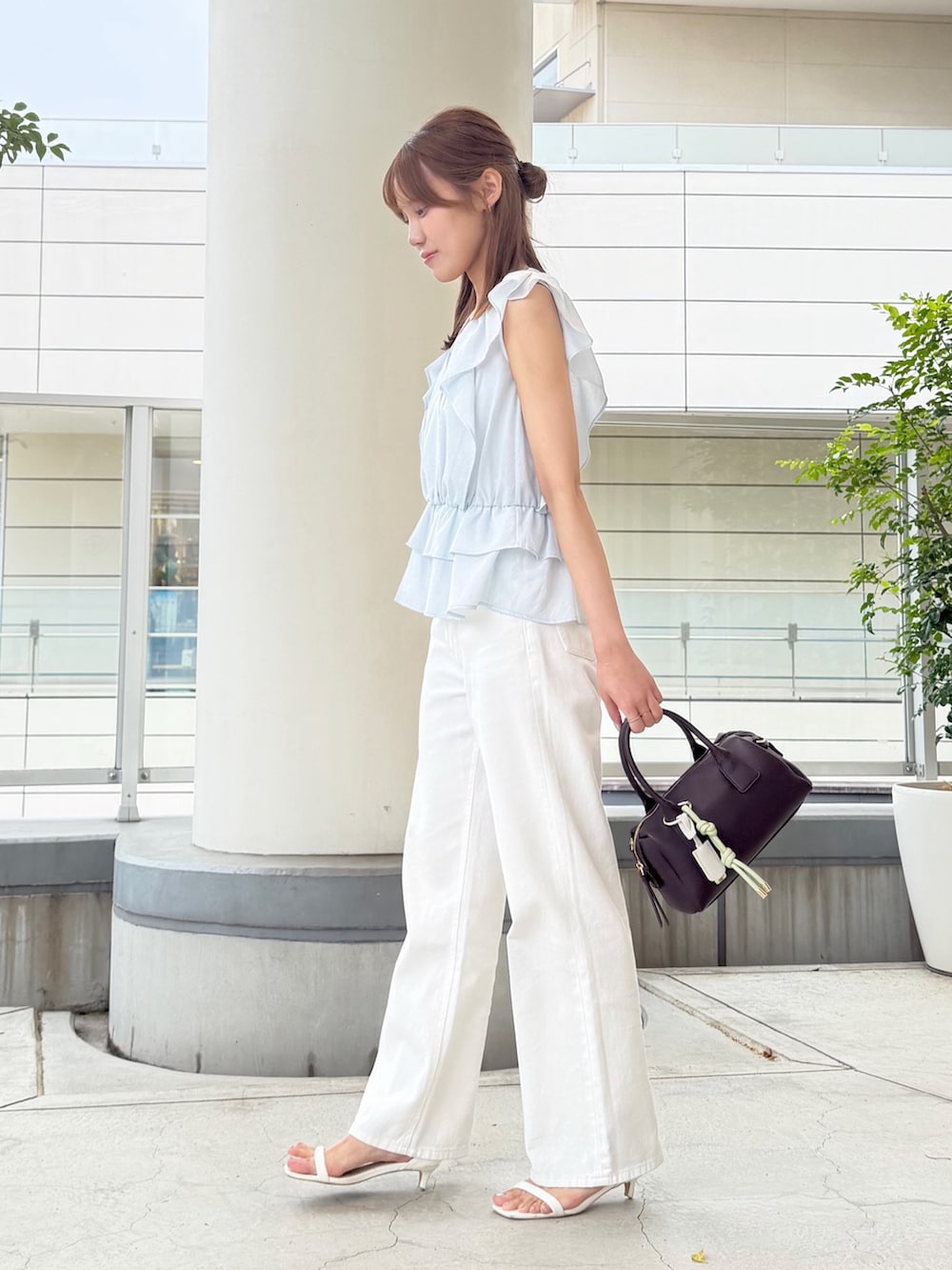ブルー系のシャツ/ブラウス、ホワイト系のデニムパンツ、ブラウン系のボストンバッグを着用したレディースの夏コーディネートの3枚目の写真
