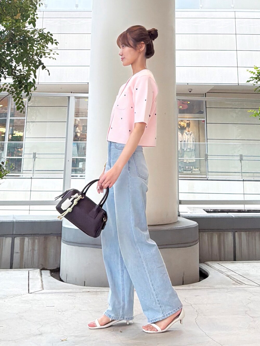 ピンク系のカーディガン/ボレロ、ブルー系のデニムパンツ、ホワイト系のボストンバッグを着用したレディースの夏コーディネートの3枚目の写真