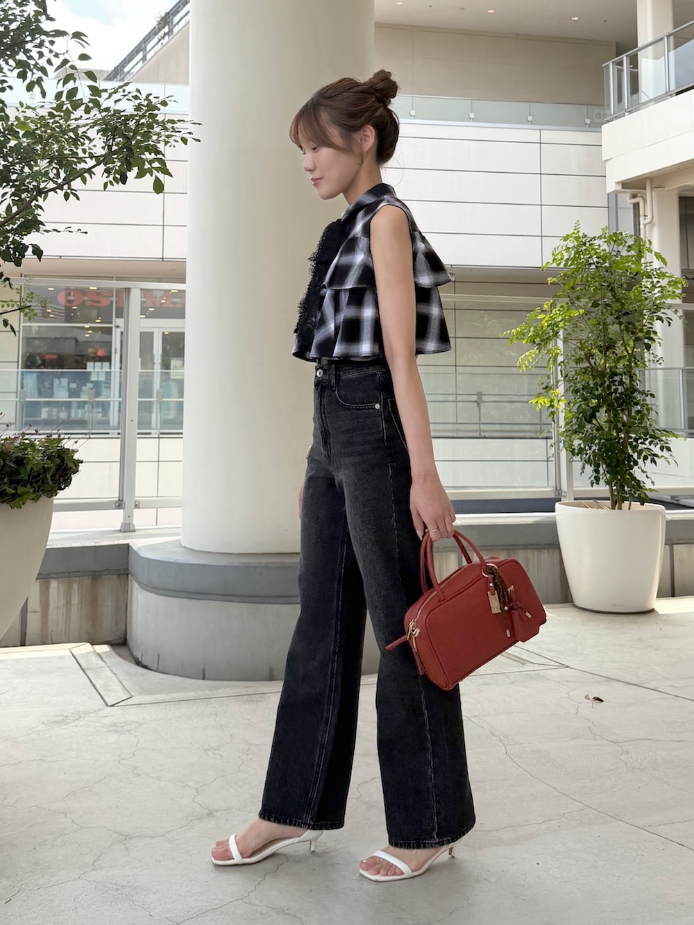 ブラック系のシャツ/ブラウス、ブラック系のデニムパンツ、オレンジ系のボストンバッグを着用したレディースの夏コーディネートの4枚目の写真