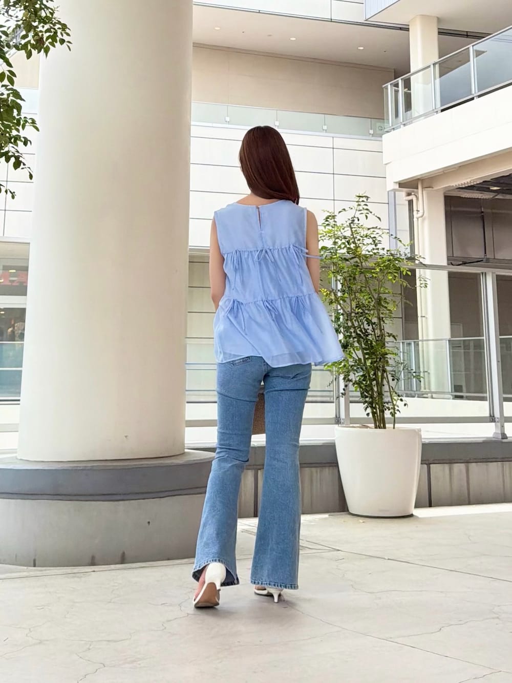 ブルー系のシャツ/ブラウス、ブルー系のデニムパンツ、ホワイト系のショルダーバッグを着用したレディースの夏コーディネートの4枚目の写真