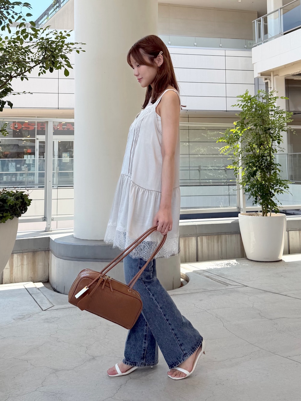 ベージュ系のキャミソール、ブルー系のその他パンツ、ブラウン系のボストンバッグを着用したレディースの夏コーディネートの3枚目の写真