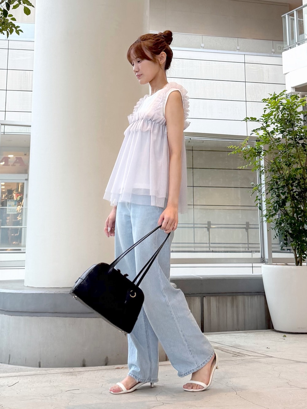 ホワイト系のTシャツ/カットソー、ブルー系のデニムパンツ、ブラック系のボストンバッグを着用したレディースの夏コーディネートの3枚目の写真