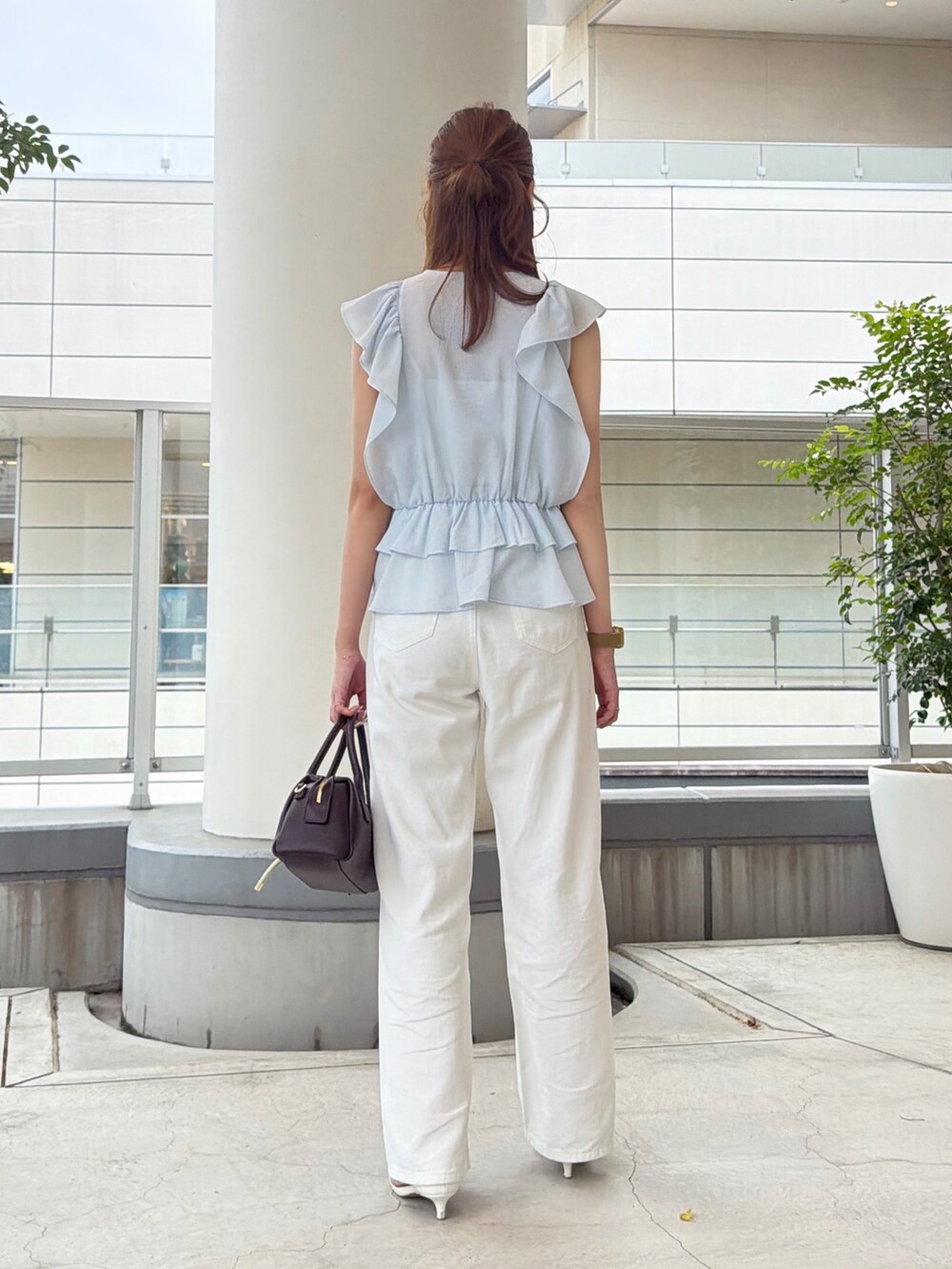 ブルー系のシャツ/ブラウス、ホワイト系のデニムパンツ、ブラウン系のボストンバッグを着用したレディースの夏コーディネートの4枚目の写真