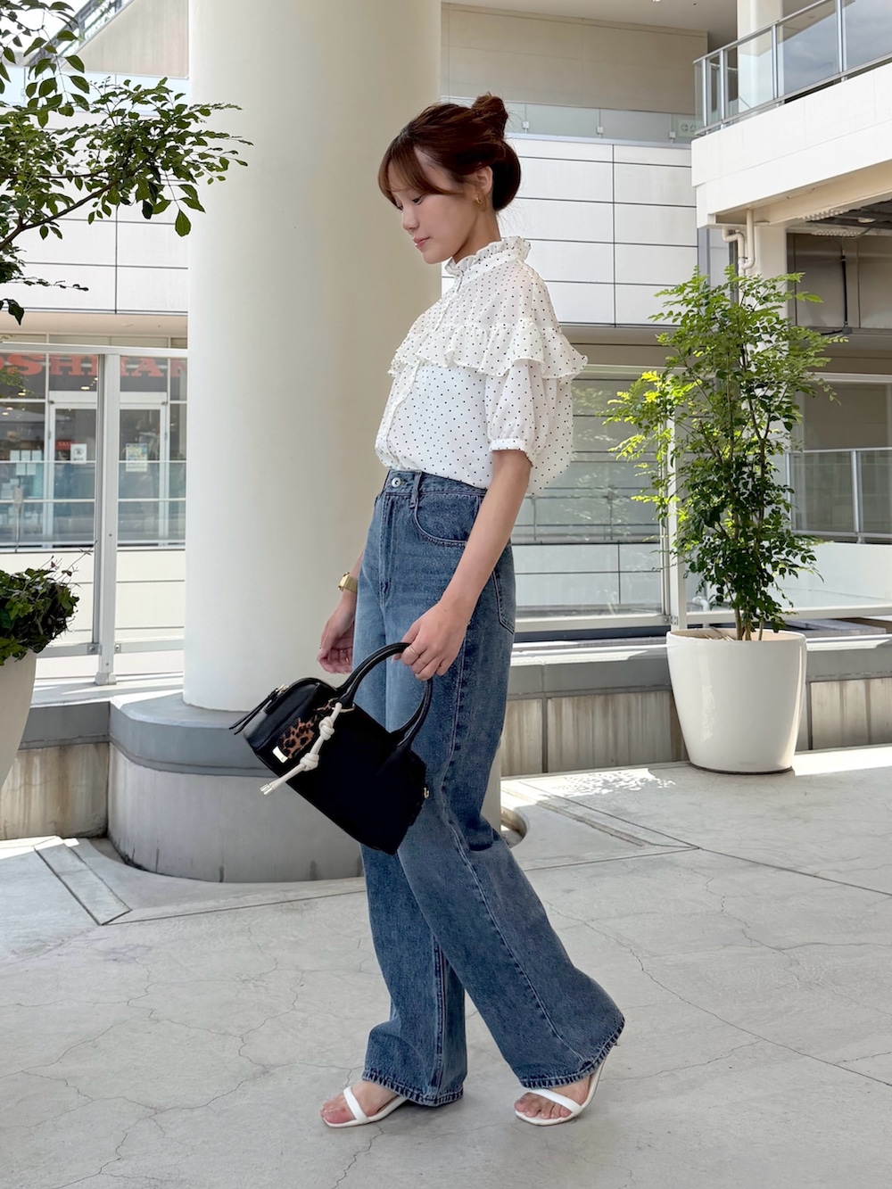 ホワイト系のシャツ/ブラウス、ブルー系のデニムパンツ、ブラック系のボストンバッグを着用したレディースの夏コーディネートの3枚目の写真