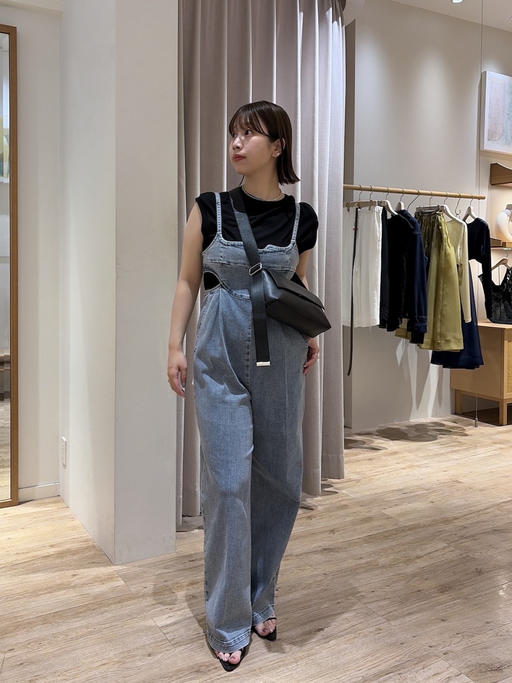 ブルー系のつなぎ/オールインワン、ブラック系のショルダーバッグ、ブラック系のTシャツ/カットソーを着用したレディースの夏コーディネートの2枚目の写真