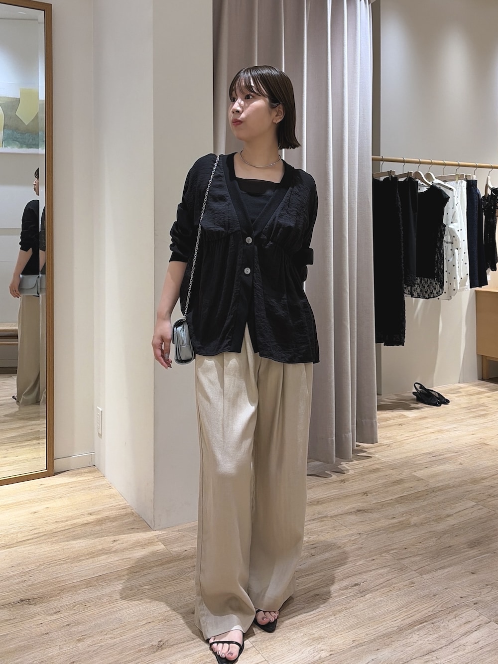 ブルー系のショルダーバッグ、ブラック系のシャツ/ブラウス、ベージュ系のその他パンツを着用したレディースの夏コーディネートの2枚目の写真