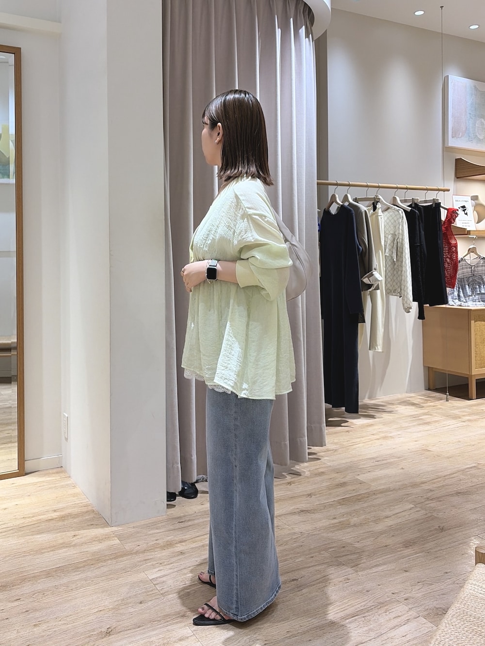 ホワイト系のキャミソール、ブルー系のデニムパンツ、グリーン系のシャツ/ブラウスを着用したレディースの夏コーディネートの4枚目の写真