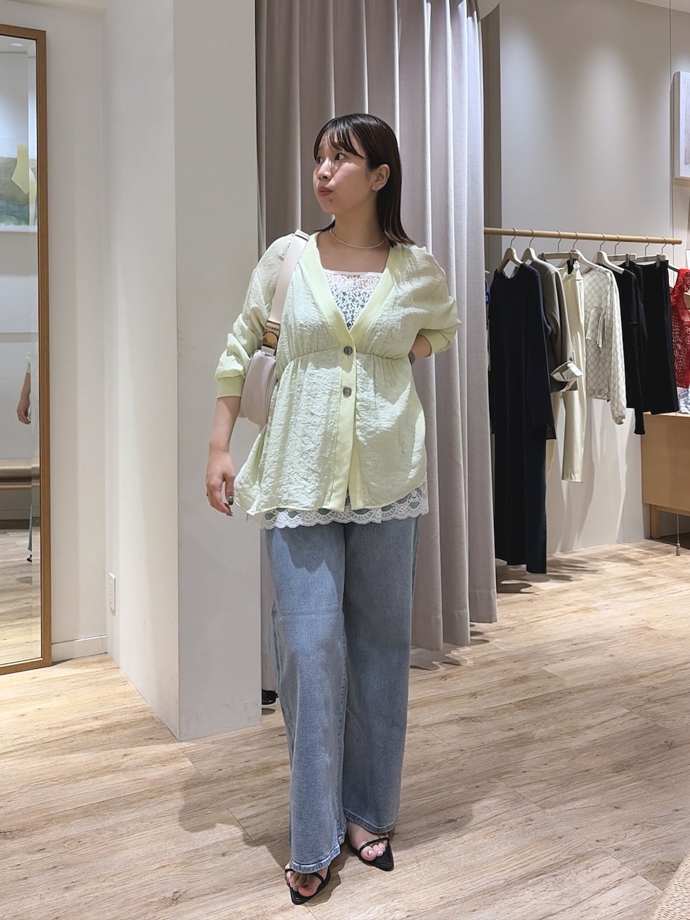 ホワイト系のキャミソール、ブルー系のデニムパンツ、グリーン系のシャツ/ブラウスを着用したレディースの夏コーディネートの2枚目の写真