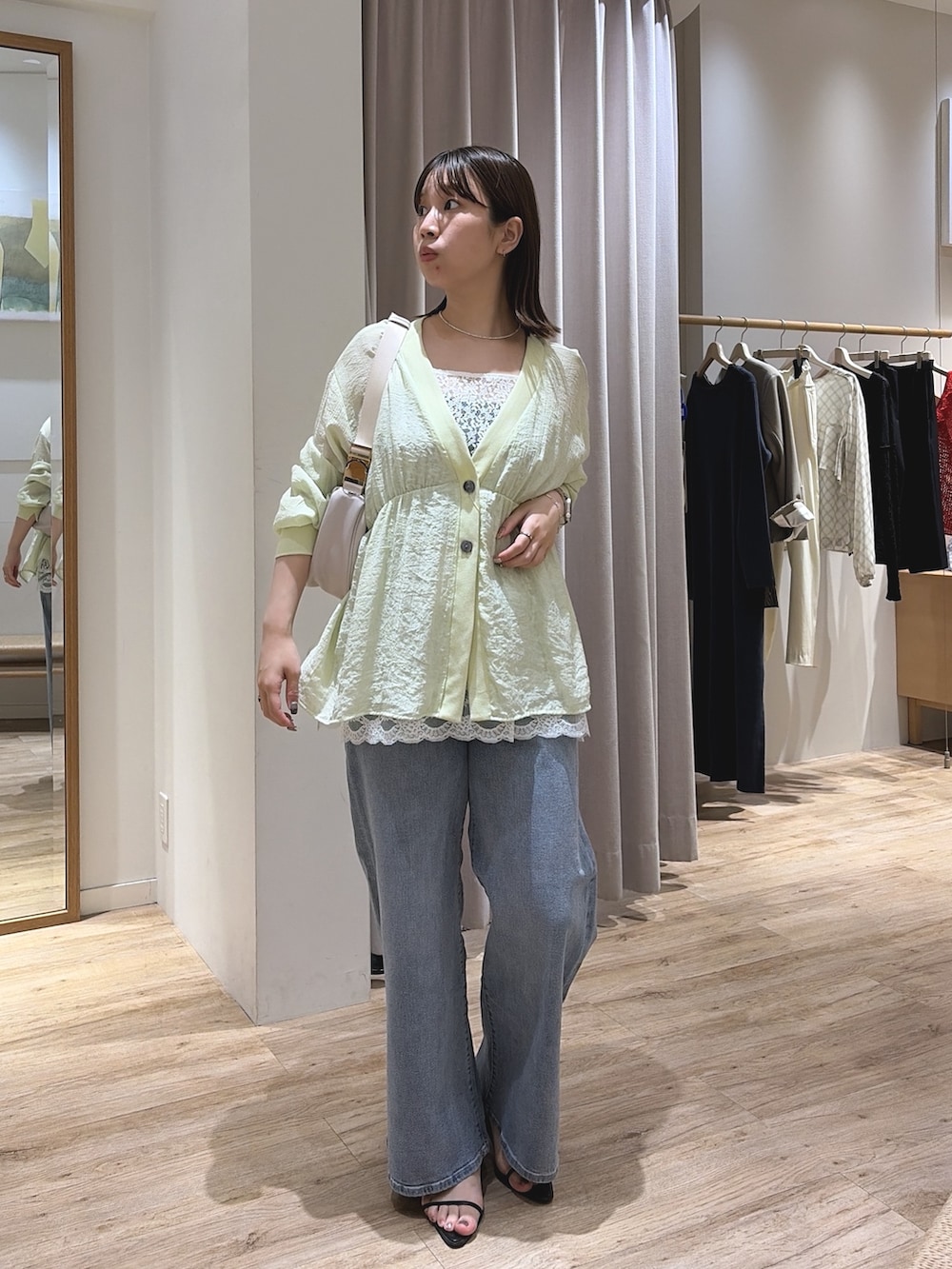 ホワイト系のキャミソール、ブルー系のデニムパンツ、グリーン系のシャツ/ブラウスを着用したレディースの夏コーディネートの3枚目の写真