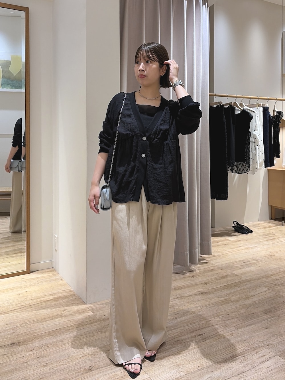 ブルー系のショルダーバッグ、ブラック系のシャツ/ブラウス、ベージュ系のその他パンツを着用したレディースの夏コーディネートの3枚目の写真